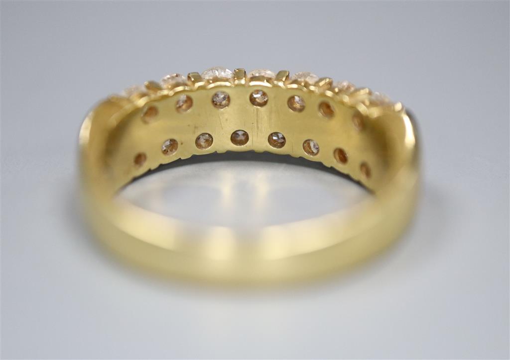 A modern 18ct gold and fifteen stone two row diamond set half hoop ring, size O, gross 6.6 grams.